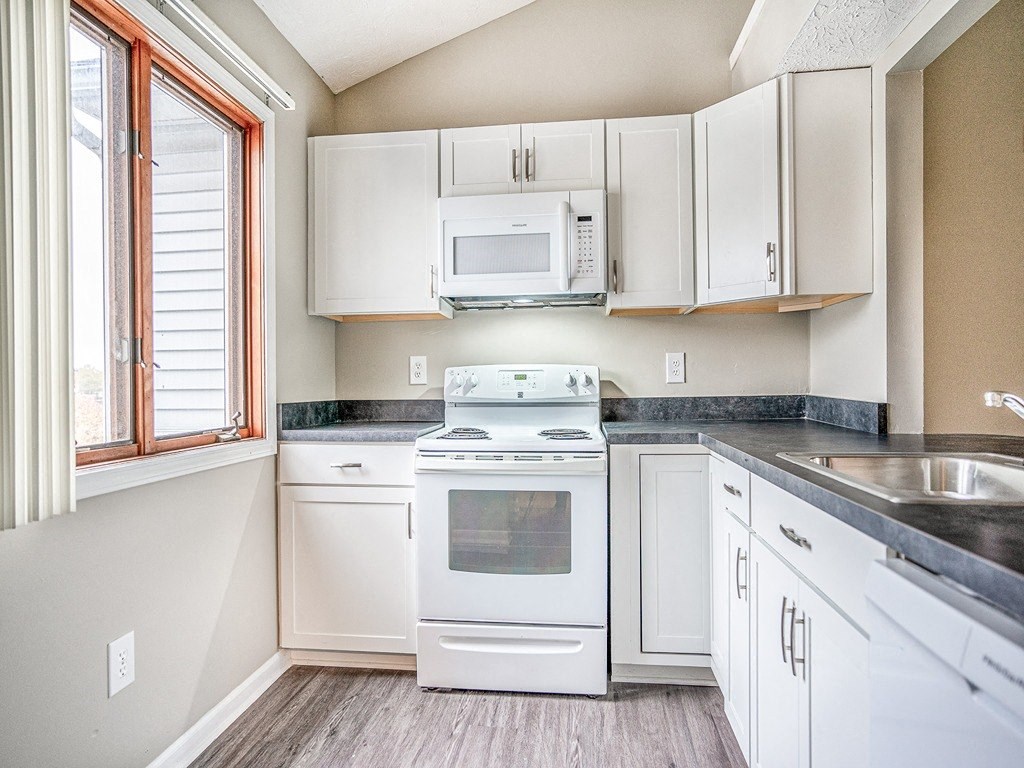 a kitchen with white appliances and white cabinets