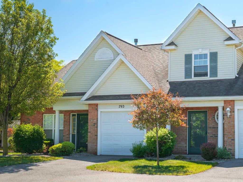 Exterior view of 2-story townhome & ranch end unit showing attached 1-car garage.
