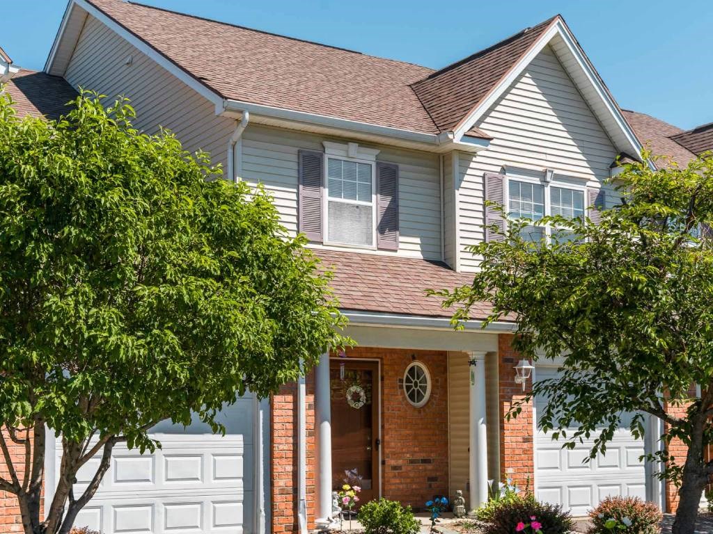Exterior view of 2-story townhome & ranch end unit showing attached 1-car garage.