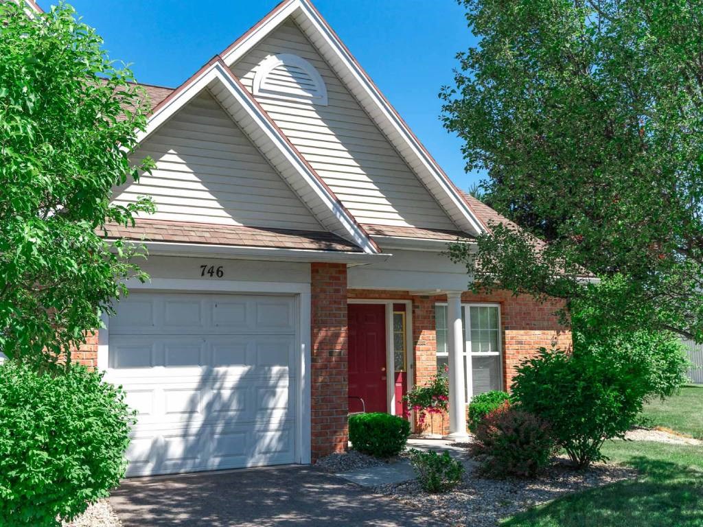 Exterior view of ranch end unit with private covered entrance & attached 1-car garage