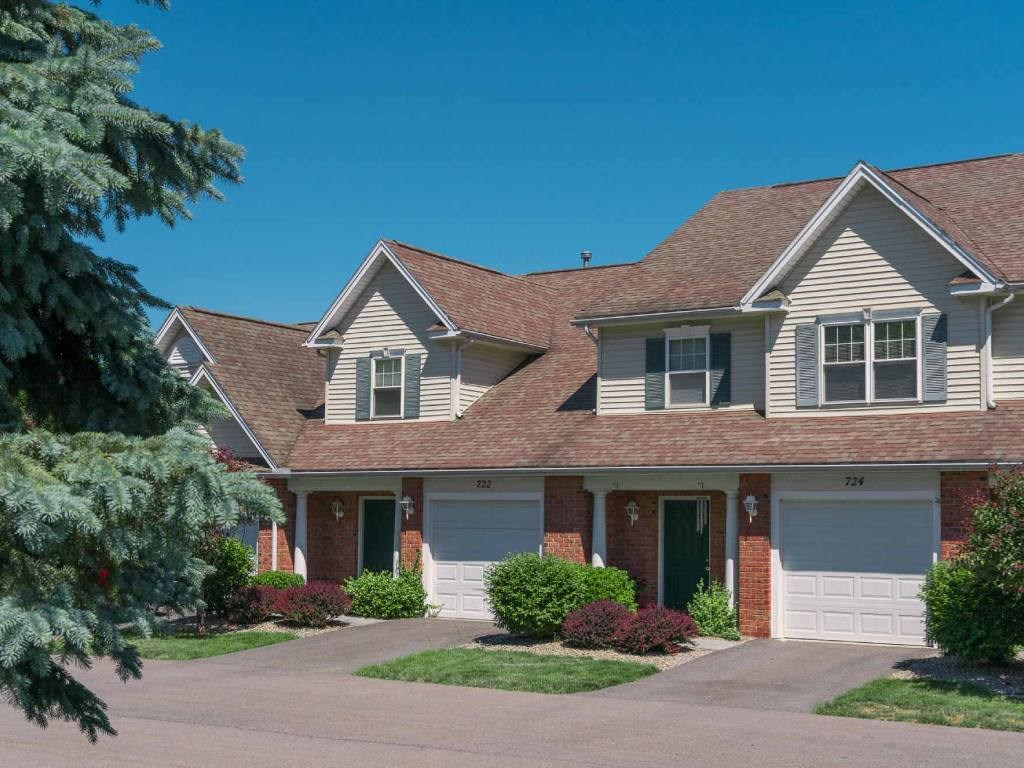 Exterior view of 2-story townhomes with private covered entrances & attached 1-car garages