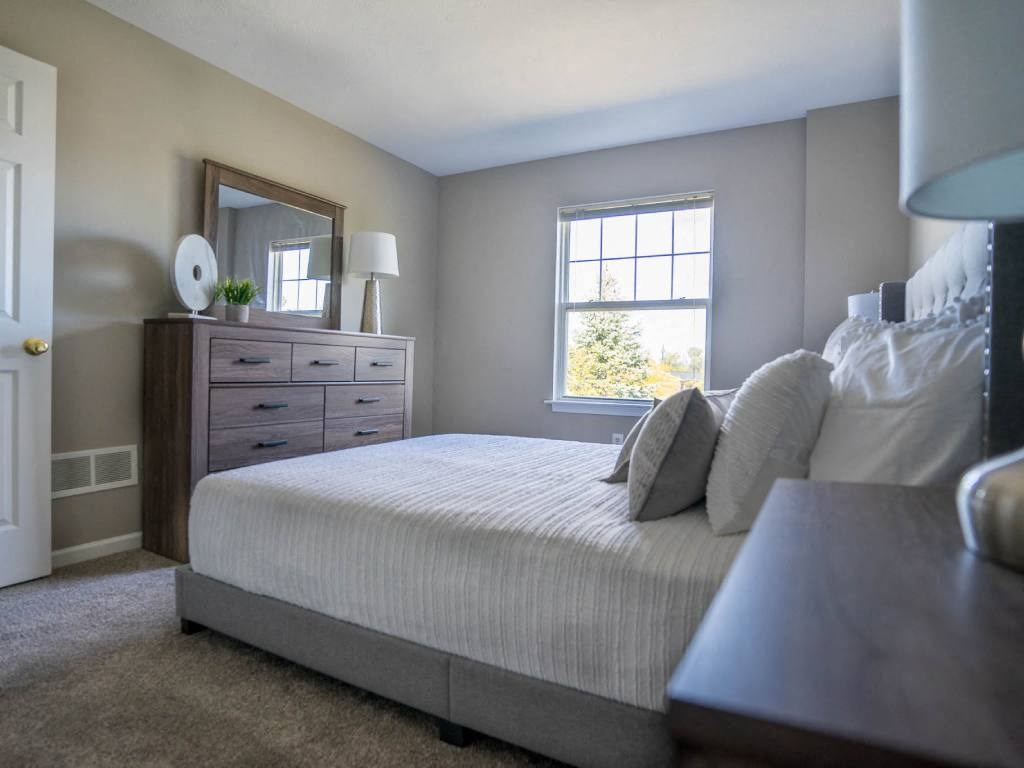 Interior view of carpeted bedroom with entrance to bathroom