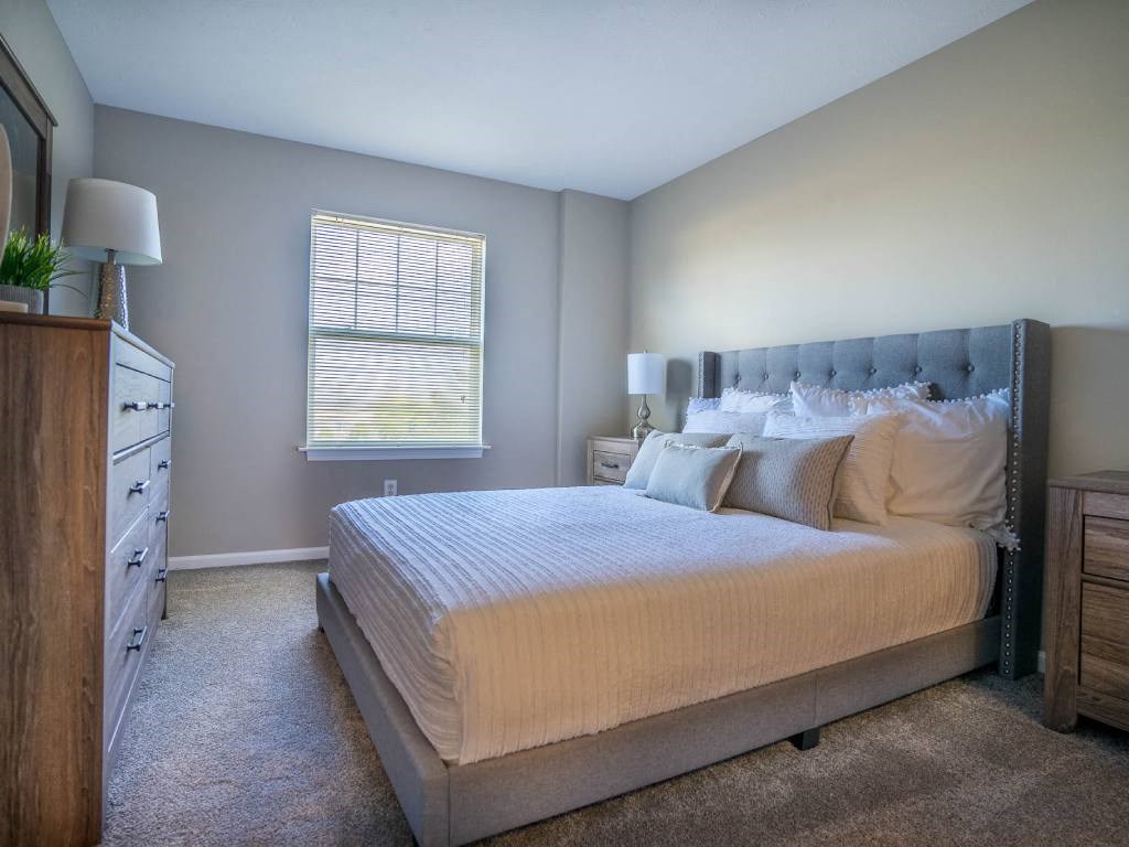 Interior view of carpeted bedroom from entrance to hallway