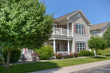 a house with a porch and a tree in front of it