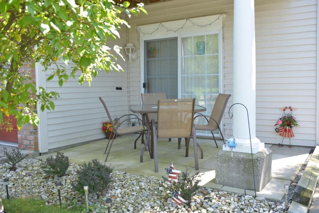 a patio with a table and chairs on a porch