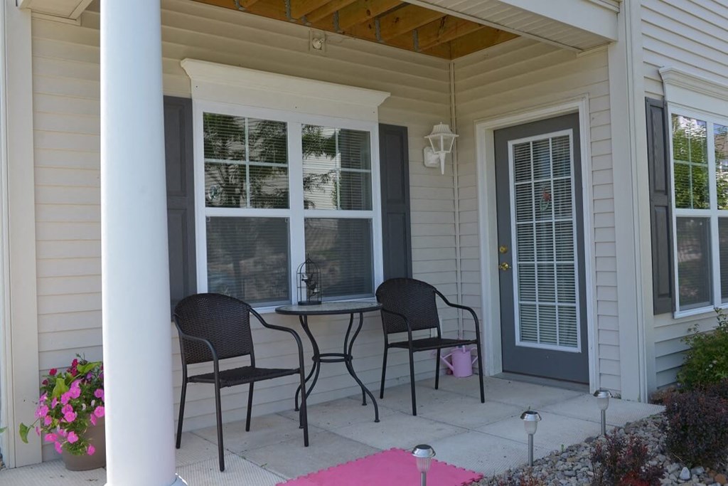 a patio with a table and chairs on a porch