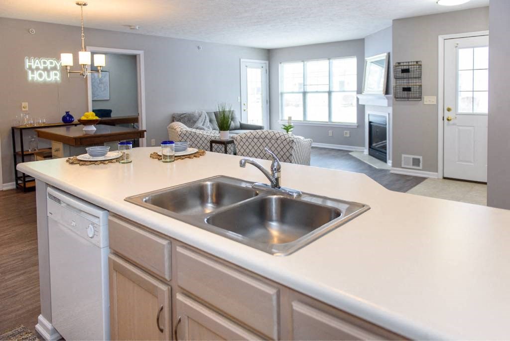 a kitchen with a sink and a living room