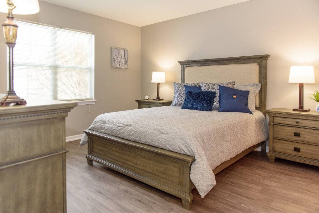 a bedroom with a bed and a dresser and a window