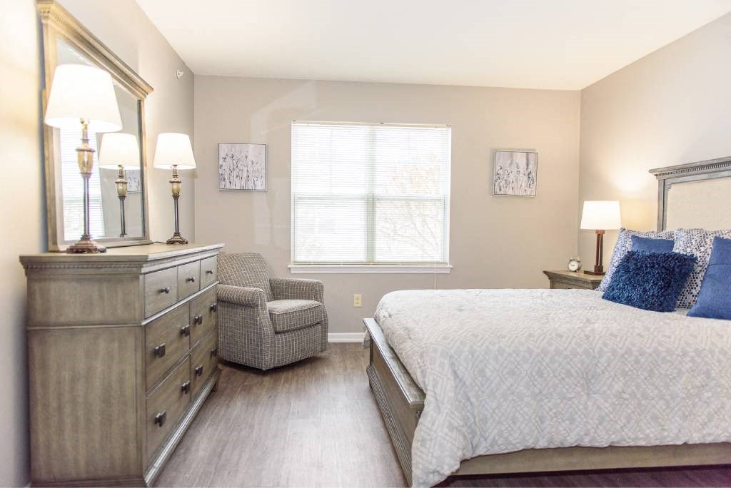 a bedroom with a bed and a dresser and a window