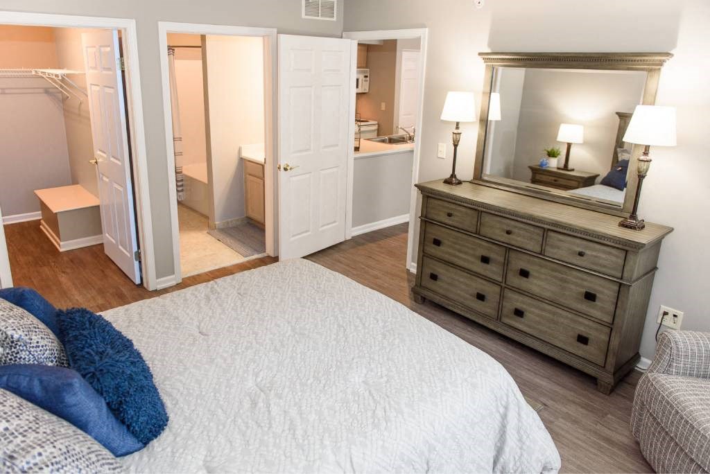 a bedroom with a bed and a dresser with a mirror