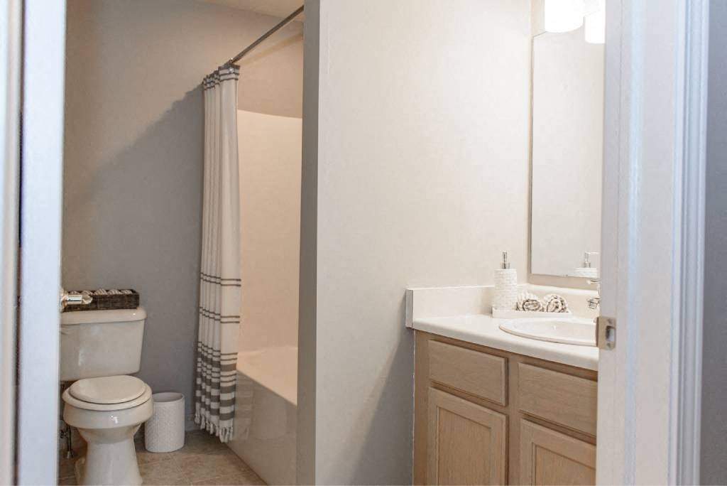 a bathroom with a toilet and a sink and a shower