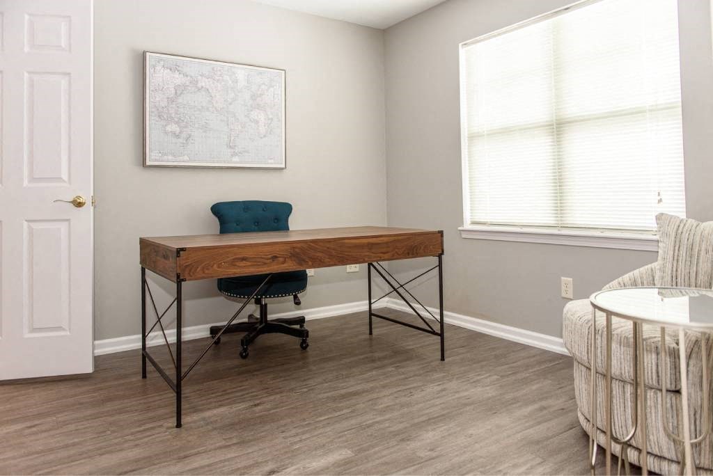 an office with a desk and a chair in a room with a couch and a