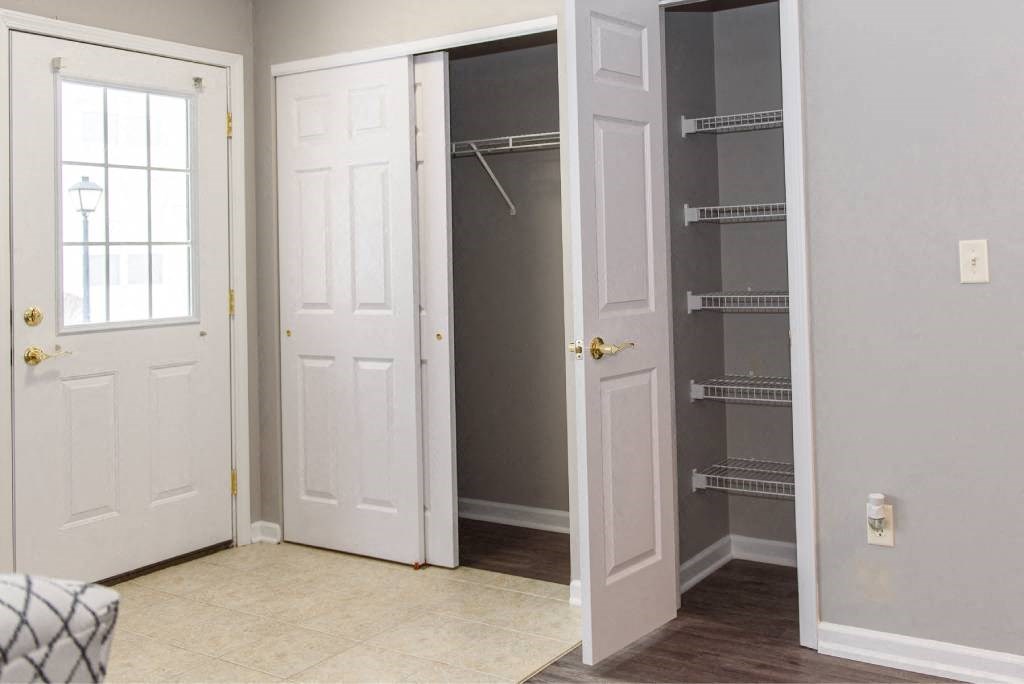 an empty closet in a room with two doors and a mirrored closet door