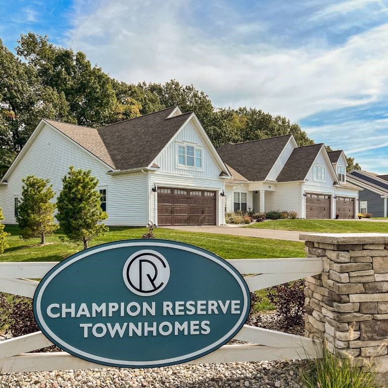 Exterior of Champion Reserve Townhomes near the Gillis Road entrance. White townhomes with attached 2-car garages.