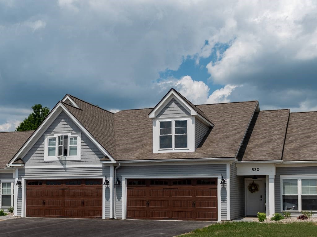 Exterior of Champion Reserve Townhomes showing blue townhomes with attached 2-car garages.