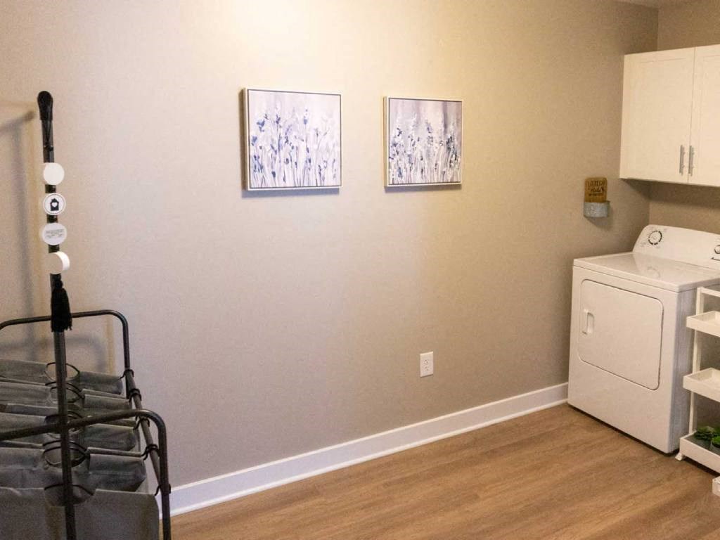 Interior of Champion Reserve Townhome spacious laundry/mudroom with full size washer and dryer and storage cupboards.