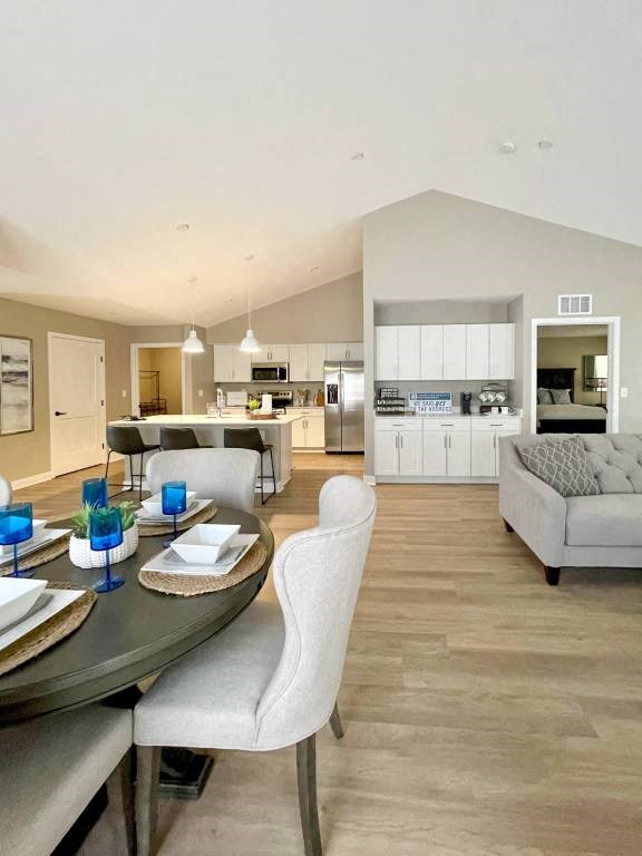 Interior of Champion Reserve Townhomes showing view from far side of dining area towards kitchen and coffee bar and cathedral ceiling.