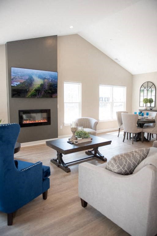 Interior of Champion Reserve Townhomes great room with cathedral ceiling, fireplace, and faux wood flooring.