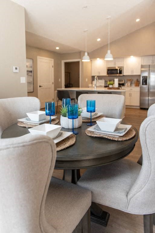 Interior of Champion Reserve Townhomes dining area with kitchen and breakfast bar in the background.