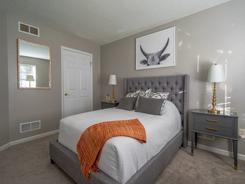a bedroom with a large bed and a mirror