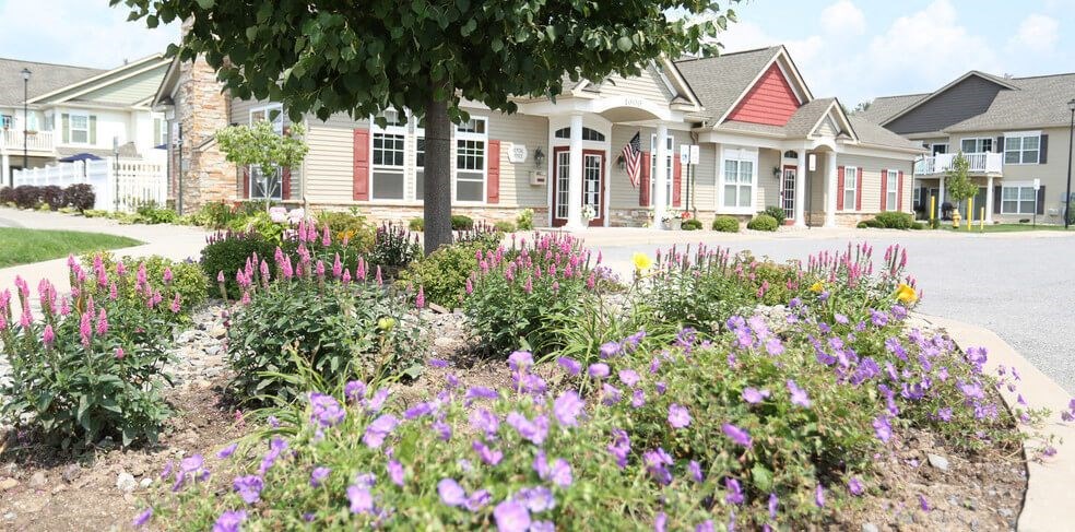 A flower bed in front of Leasing Office, Community Center, & Fitness Center building