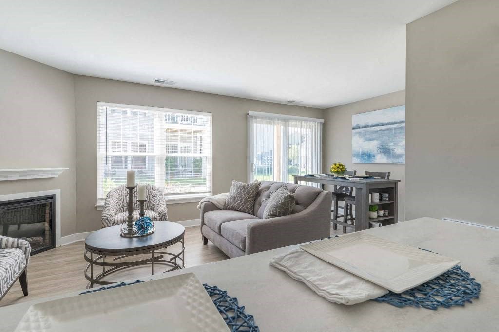 View from breakfast bar towards great room living area with fireplace and dining area with sliding glass doors to private patio or balcony
