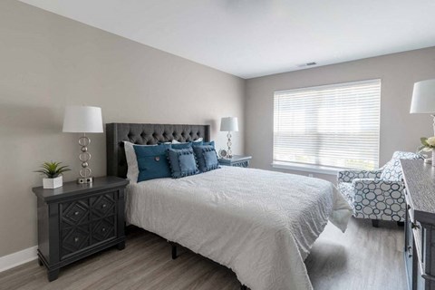 View of spacious bedroom with plank flooring, large windows