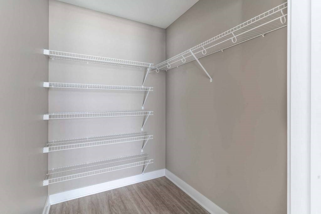 Large walk-in closet off primary bedroom with shelving and clothing rods