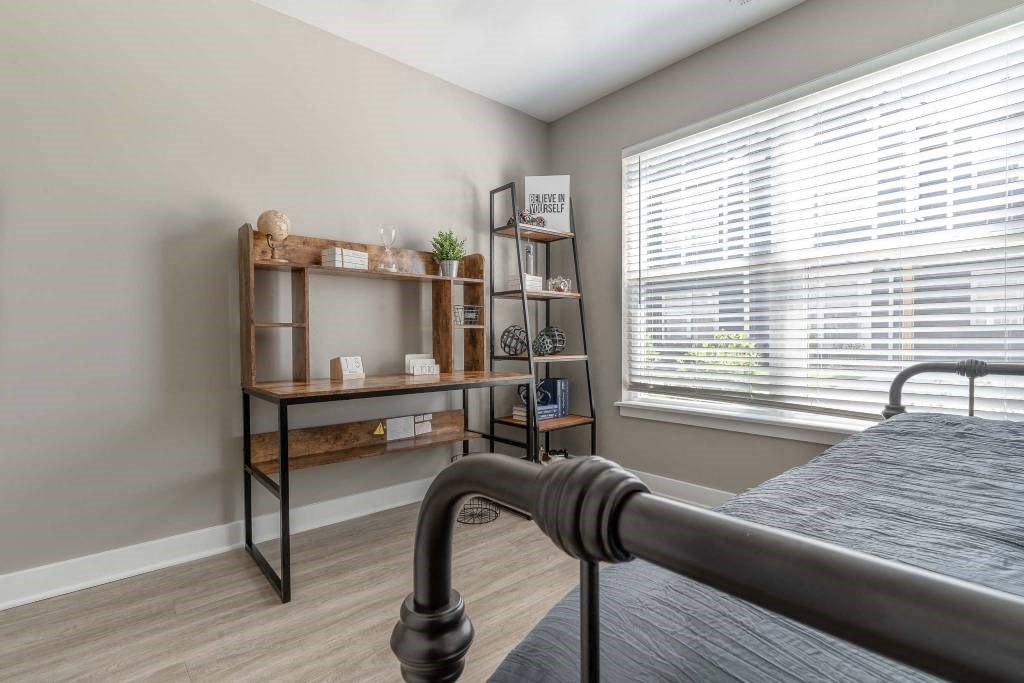 Second bedroom with large, bright windows and plank flooring