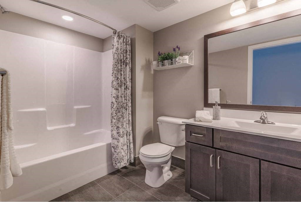 Second full bathroom with shower/tub combo, large vanity, and tile flooring
