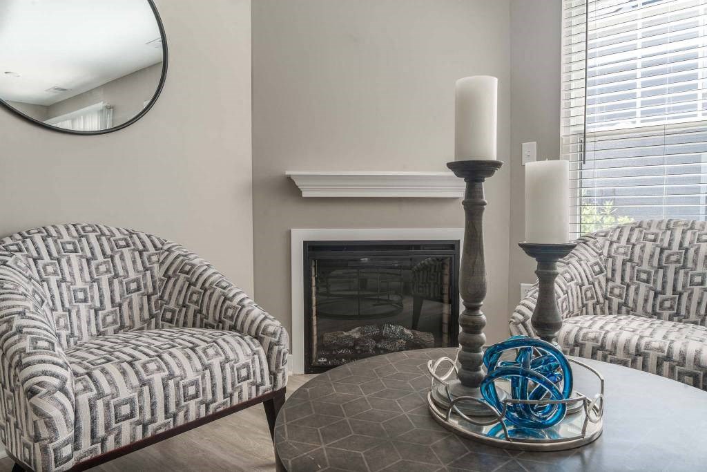 a living room with two chairs and a table and a fireplace