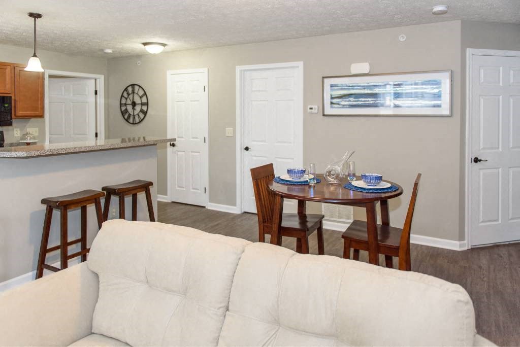 View from living area of great room towards dining area and kitchen with breakfast bar