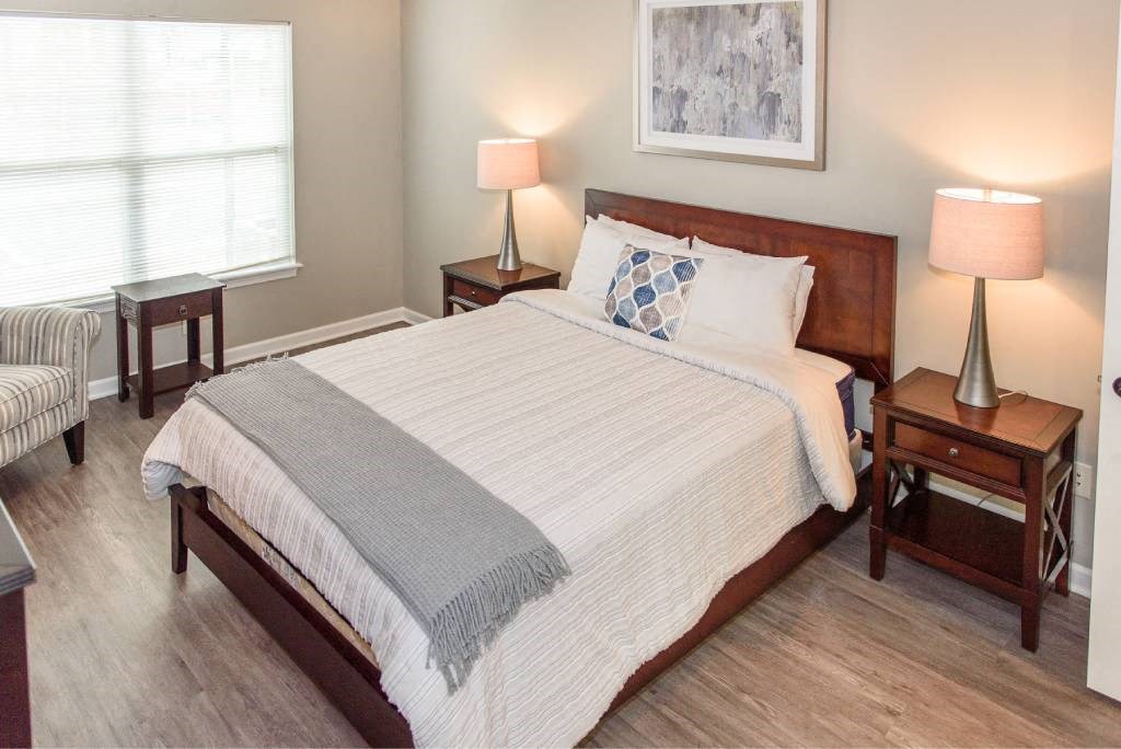 Spacious bedroom with large, bright windows and plank flooring