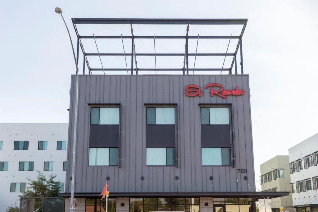 a gray building with a red sign on top of it