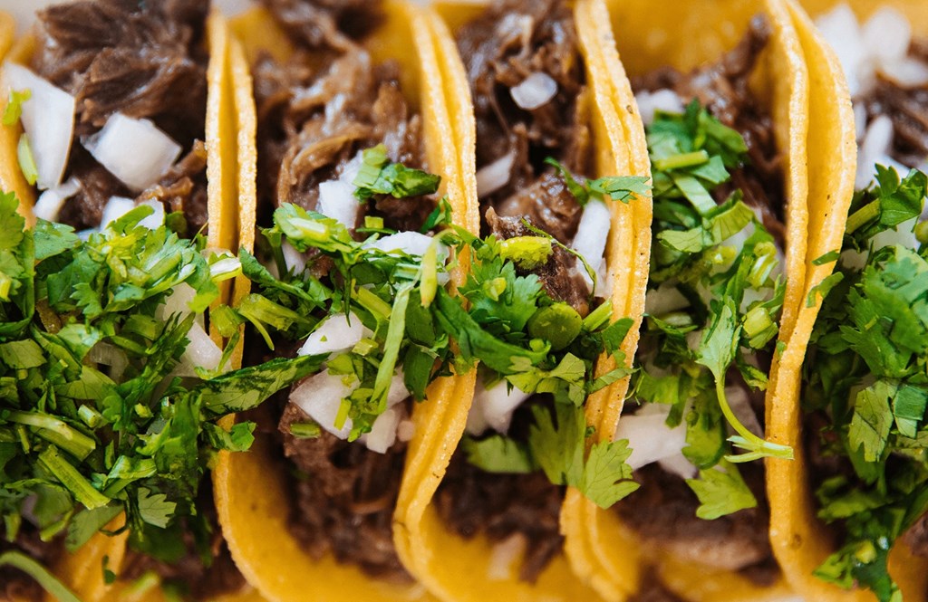 a close up of tacos with meat and toppings