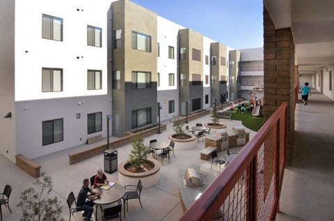 people sitting at tables in a courtyard of a building