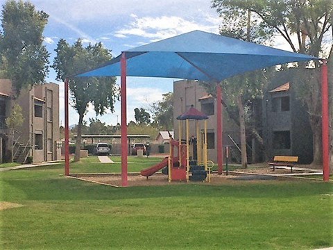 a playground with a blue canopy in a park