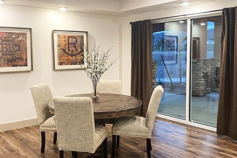 a dining room with a table and chairs and sliding glass doors
