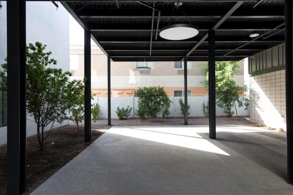 a courtyard with trees and a light hanging from the ceiling