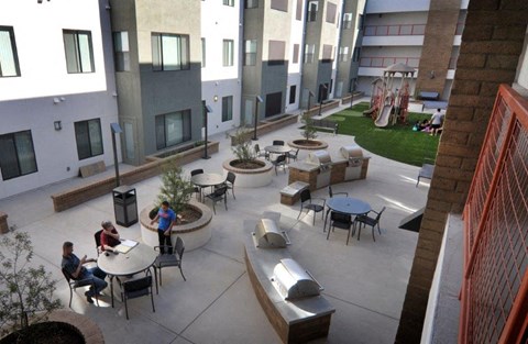 a group of people sitting at tables in a courtyard