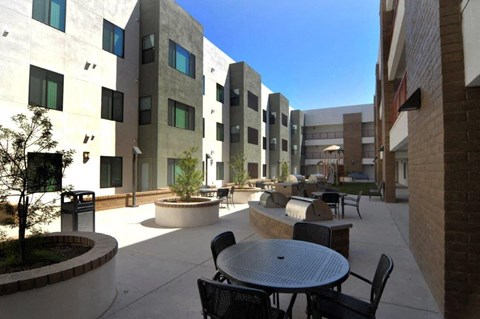 a patio with tables and chairs outside of a building