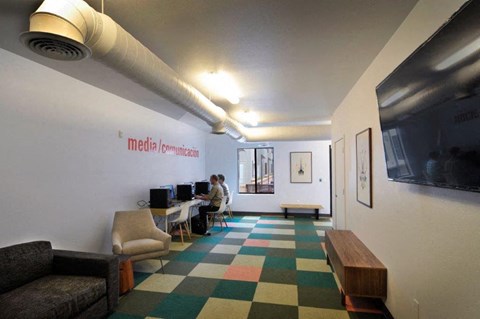 a man sitting at a desk in a room with a computer