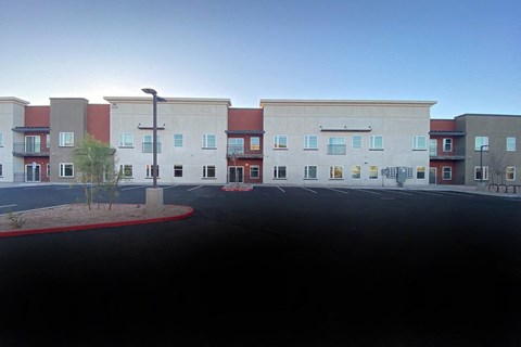 an empty parking lot in front of an apartment building