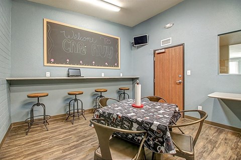 a dining room with a table and a chalkboard on the wall
