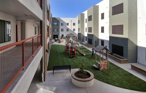 a view of the courtyard of an apartment building with a playground
