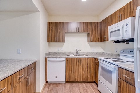 A kitchen with wooden cabinets and white appliances.