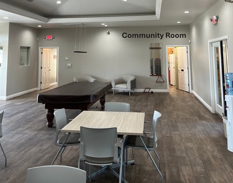 A community room with a table and chairs.