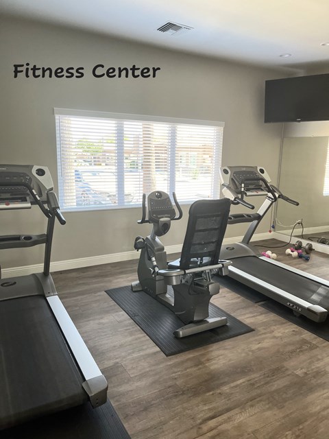A fitness center with treadmills, elliptical machines, and a stationary bike.