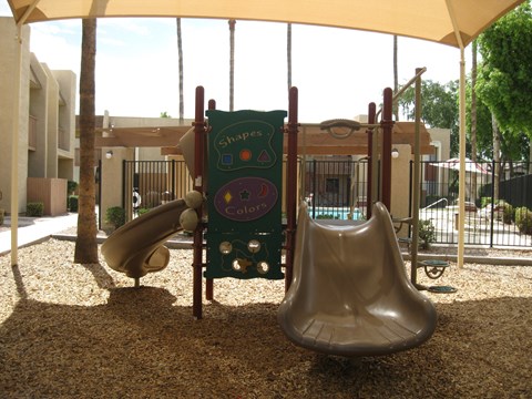 a playground with two slides and a swing set