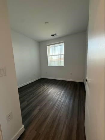 A room with wooden floors and a window.
